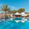Piscina con palme e sedie a sdraio.