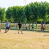 Ragazzi giocano a calcio su campo erboso.