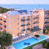 Hotel con piscina vista mare, palme e balconi.