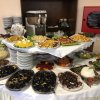 Tavolo da buffet con piatti vari, tra cui frutti di mare e verdure.