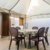 Tavolo sotto gazebo con sedie marroni.