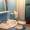 Bagno con piastrelle blu, lavandino, WC e doccia.