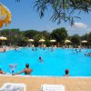 Persone in una piscina con ombrelloni gialli.