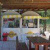 Chiosco gelati Algida all'aperto con tavoli e sedie.