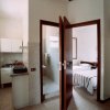 Cucina e camera da letto con porta aperta.