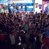 Festa con una folla che balla davanti a un palco in un ambiente notturno.