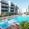 Piscina all'aperto con edificio moderno sullo sfondo.