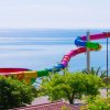 Scivolo d'acqua colorato e curvo che si affaccia sul mare blu.