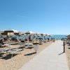 Spiaggia con ombrelloni bianchi e lettini.