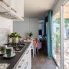 Cucina moderna con tavolo apparecchiato e vista sul patio.