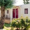 Casa mobile con veranda fiorita e giardino verde.
