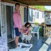 Due persone con un cane su una veranda di casa mobile.