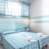 Camera con due letti, arredamento azzurro a righe.